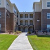 a large building with trees and a sidewalk