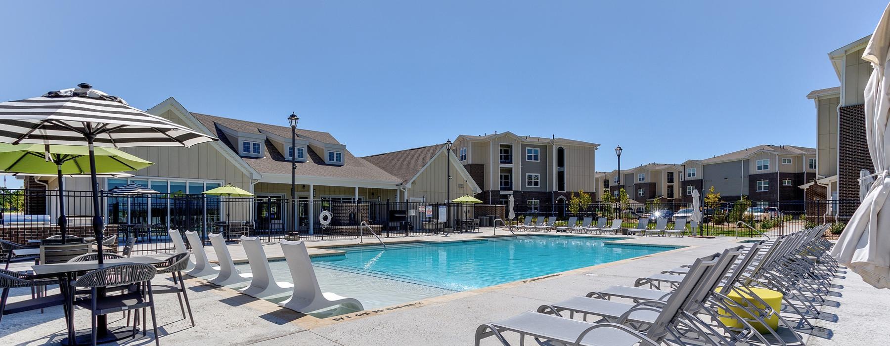 a swimming pool with a few chairs and umbrellas